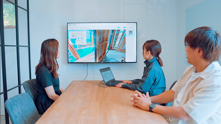 A team in a meeting room watches a remote site inspection via Insta360 camera.