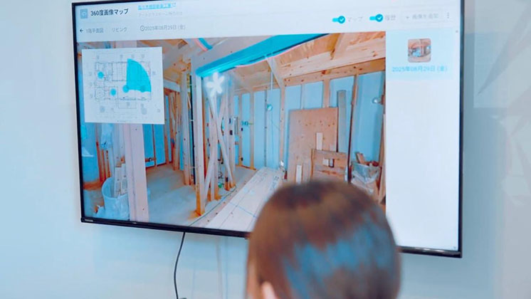 A woman in a meeting watches a digital construction site.