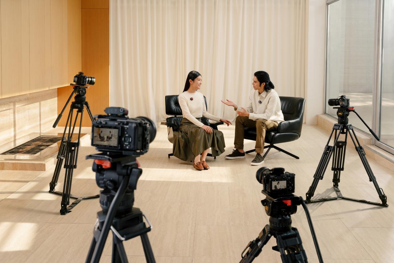 An interview takes place between two people with multiple cameras from different angles, linked to Insta360 Mic Pro wirelessly.