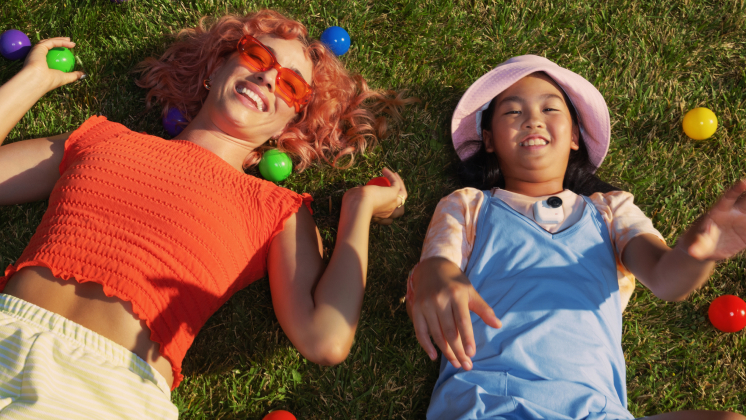 two girls lying on grass with insta360 go ultra chest-mounted pov camera