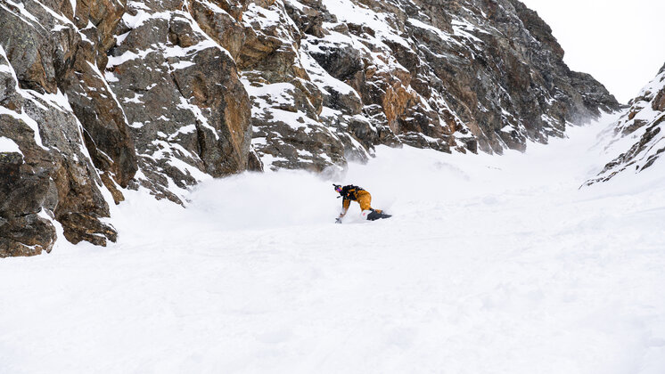 Jakob Weger snowboarding down a rocky mountain.