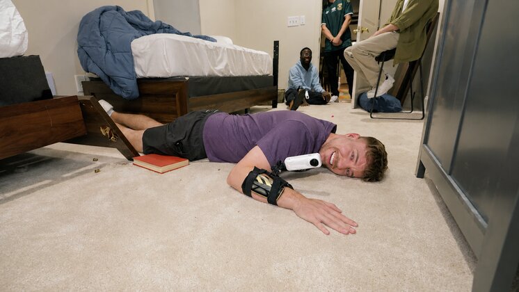 MrBeast laying on the carpeted floor of a house for his latest challenge. An Insta360 camera is strapped to his wrist.